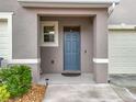 Inviting covered front porch with blue door, neutral paint, and landscaped flower bed at 1042 Lido Dr, Howey In The Hills, FL 34737