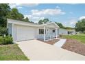 Single-story home with attached garage and cozy front porch at 11214 Sw 77Th Ct, Ocala, FL 34476