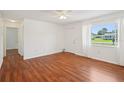 Bright living room features hardwood floors, white walls, ceiling fan, and natural light at 11214 Sw 77Th Ct, Ocala, FL 34476