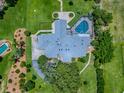 Birds-eye view showcases a large home with a screened pool, complemented by lush landscaping at 11226 Lane Park Rd, Tavares, FL 32778