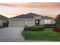 Beautiful single-story home with a well-manicured lawn, three-car garage, and welcoming entrance at 1304 Zombar Pl, The Villages, FL 32163
