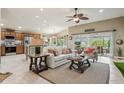 Bright living room with a ceiling fan, tile floors, and view of the kitchen at 1304 Zombar Pl, The Villages, FL 32163