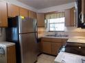 Functional kitchen with stainless steel refrigerator, double sinks, and ample cabinet space at 1485 Morningside Dr, Mount Dora, FL 32757