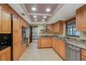 Well-lit kitchen features stainless steel appliances, light wood cabinets, and beautiful granite countertops at 15935 J And J Dr, Tavares, FL 32778