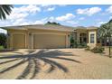 Lovely single story home featuring a three-car garage, desert landscaping, and a brick paved driveway at 2204 Baypoint Way, The Villages, FL 32162