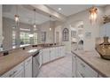Open kitchen with white cabinetry, granite countertops, stainless steel appliances, and pendant lighting at 2204 Baypoint Way, The Villages, FL 32162