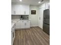 Modern kitchen with white cabinets, stainless steel appliances, and wood-look flooring at 2227 S Spring Garden Ave, Deland, FL 32720