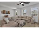 Bright living room with a cozy sectional sofa, ceiling fan, and ample natural light at 2552 Chickasaw Plum Loop, Clermont, FL 34711