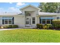 Charming home with manicured lawn and beautiful, bright entryway at 26030 Newcombe Cir, Leesburg, FL 34748