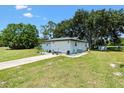 Rear exterior view of a single story home with an attached garage and well-kept lawn at 2845 County Road 523, Wildwood, FL 34785
