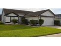 This single-story home features a well-manicured lawn and a two-car garage with concrete driveway at 3041 Bloomsbury Dr, Kissimmee, FL 34747