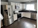 Modern kitchen featuring stainless steel appliances, white cabinets, and dark countertops at 3041 Bloomsbury Dr, Kissimmee, FL 34747