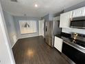 Bright kitchen with stainless steel appliances, hardwood floors and a dining area at 3041 Bloomsbury Dr, Kissimmee, FL 34747
