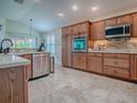 Well-lit kitchen boasts updated stainless steel appliances and custom wood cabinets, perfect for home cooking at 3136 Vandenberg Ct, The Villages, FL 32163