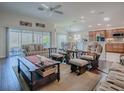 Inviting living room features hardwood floors, a ceiling fan, and sliding glass doors with a view of the lanai at 3136 Vandenberg Ct, The Villages, FL 32163