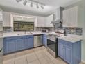 Beautiful kitchen showcasing stainless steel appliances, white cabinets, and stylish backsplash at 3380 Blossom St, Kissimmee, FL 34746