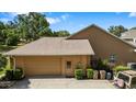 Exterior view of a home's garage, featuring a tan exterior and well-maintained surroundings at 34021 Park Ln, Leesburg, FL 34788