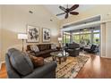 Spacious living room with hardwood floors, high ceilings, and sliding glass doors to the sunroom at 34021 Park Ln, Leesburg, FL 34788
