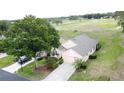 Aerial view of a well-maintained home with landscaping, driveway, and proximity to green spaces at 3525 Rollingbrook St, Clermont, FL 34711