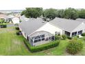 Aerial view of a backyard featuring a screened-in patio, lush lawn, and well-maintained hedges at 3525 Rollingbrook St, Clermont, FL 34711