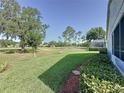 Expansive backyard overlooking a golf course, featuring lush green grass and mature trees at 3706 Doune Way, Clermont, FL 34711