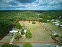 Aerial view of a property with large lot, showcasing potential for expansion and privacy, enclosed by a red line at 37149 Grays Airport, Lady Lake, FL 32159