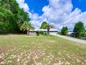 Charming home featuring a well-manicured lawn and mature palm trees, creating a welcoming curb appeal at 37149 Grays Airport, Lady Lake, FL 32159