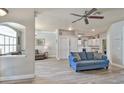 Open-concept living room featuring wood-look floors, modern ceiling fan, and seamless flow into the kitchen at 3732 Fallscrest Cir, Clermont, FL 34711