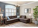Cozy living room with large window, sectional sofa, stylish lighting, and wood-look floors at 3732 Fallscrest Cir, Clermont, FL 34711