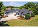 An aerial view of the home featuring a lush lawn, palm trees and large driveway at 39634 Harbor Hills Blvd, Lady Lake, FL 32159