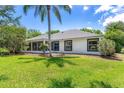 Home's exterior features a screened-in patio and a lush green yard at 39634 Harbor Hills Blvd, Lady Lake, FL 32159