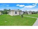 Single-story home with bright blue door and cozy front porch, surrounded by green lawn at 4649 College Dr, Orlando, FL 32811