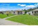 Single-story home with well-manicured lawn, a inviting blue door, and cozy porch at 4649 College Dr, Orlando, FL 32811