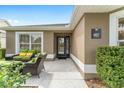 Inviting front porch with stylish outdoor seating, lush landscaping, and the home's address plaque at 467 Weston Manor Dr, The Villages, FL 32162