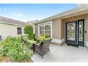 View of the front porch with cozy outdoor seating, a welcoming entrance, and colorful garden at 467 Weston Manor Dr, The Villages, FL 32162