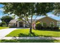 Single-story home features a well-manicured lawn and lush landscaping in a quiet residential neighborhood at 4835 Calasans Ave, St Cloud, FL 34771