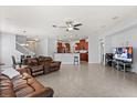 Open-concept living space with tile floors, a large leather sofa, and access to the kitchen at 4869 Grassendale Ter, Sanford, FL 32771