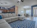 Open-concept living space with a large sectional sofa, view of the kitchen, and a dining area with natural light at 4976 Sandpiper Dr, Oxford, FL 34484