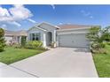 Attractive single-story home with a well-maintained lawn and a convenient two-car garage at 5043 Stokes Way, Wildwood, FL 34785