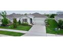 Inviting single-story home featuring a well-kept lawn, complemented by a spacious driveway at 5043 Stokes Way, Wildwood, FL 34785