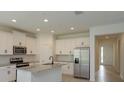 Modern kitchen with white cabinetry, stainless steel appliances, granite countertops and an island with a sink at 5045 Balsam Falls Rd, Deland, FL 32724