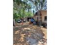 Large backyard with parking and storage sheds surrounded by mature trees at 5643 County Road 173, Wildwood, FL 34785