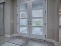 Elegant entryway features frosted glass doors and a stylish rug at 5905 Caulk Ct, The Villages, FL 32163