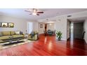 Bright living room with red wood floors, neutral paint, stylish furniture, and an open layout at 601 W Old Hwy 441 # 11B, Mount Dora, FL 32757