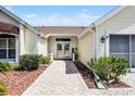 Close up view of the home's entryway with beautiful pavers and landscaping at 815 Cortez Ave, The Villages, FL 32159