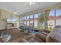 Bright sunroom with many windows, ceiling fan, and a cozy seating area at 815 Cortez Ave, The Villages, FL 32159