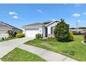 Pleasant single-Gathering home featuring a two-car garage, lush lawn, and stone accents at 8178 Penrose Pl, Wildwood, FL 34785