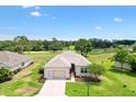 Aerial view showcasing the home's desirable location on a golf course with lush green surroundings and a well-kept lawn at 8779 Se 141St Lane Rd, Summerfield, FL 34491