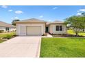 Inviting home with a well-manicured lawn, landscaped garden beds, and a charming facade, perfect for suburban living at 8779 Se 141St Lane Rd, Summerfield, FL 34491