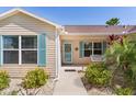Inviting front porch with swing, blue shutters and a beautifully landscaped walkway at 898 Abaco Path, The Villages, FL 32163
